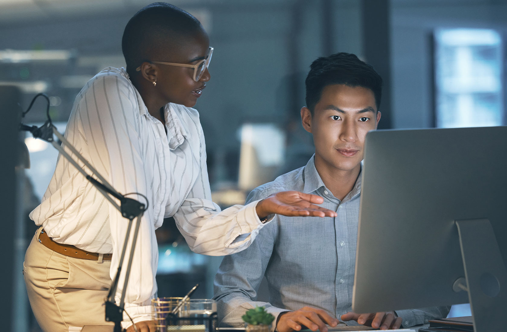 Mand and a woman discuss work and look at a computer