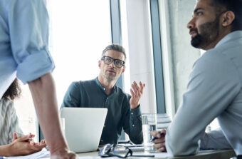 Business man in discussion with colleague at meeting table