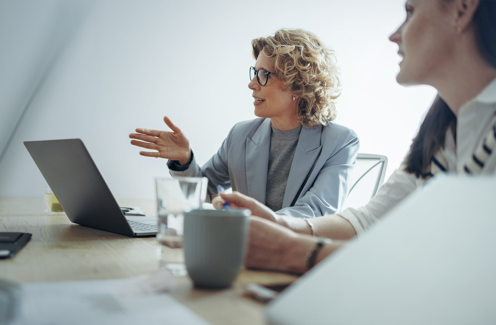 Business women in a discussion at an office table with a laptop